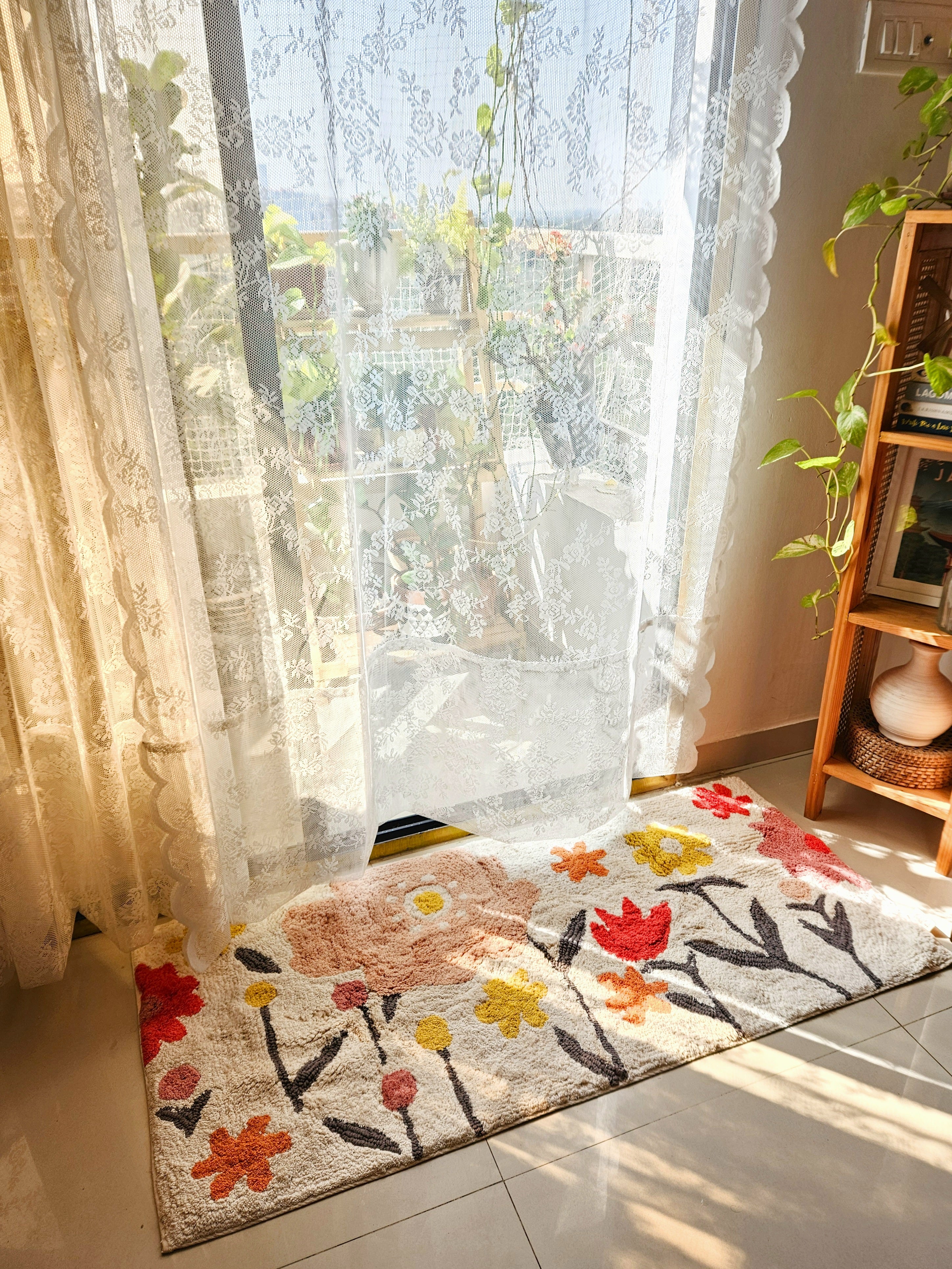Top-view of the Blossom Trail Rug placed on a wooden floor, showcasing its boho tufted pattern and earthy color palette.

