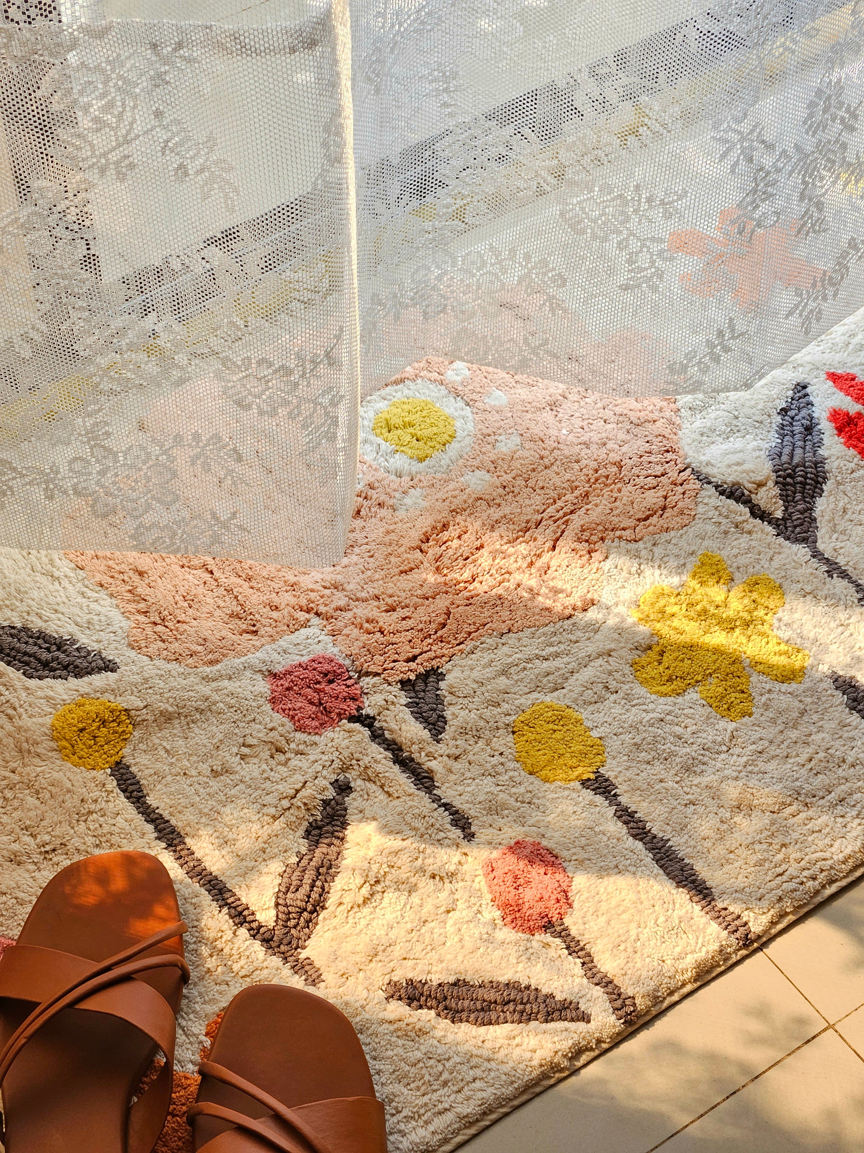 Close-up of the bohemian-style tufting and woven cotton textures on the Blossom Trail Rug.

