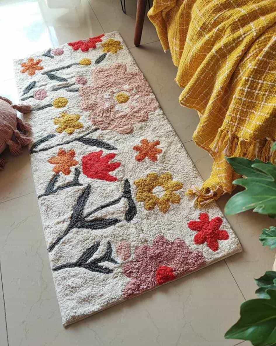 Top-view of the Blossom Trail Rug placed on a wooden floor, showcasing its boho tufted pattern and earthy color palette.

