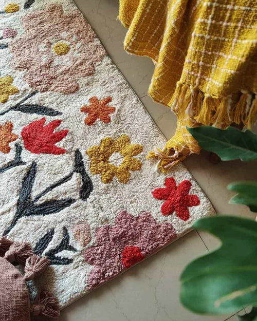 Close-up of the bohemian-style tufting and woven cotton textures on the Blossom Trail Rug.

