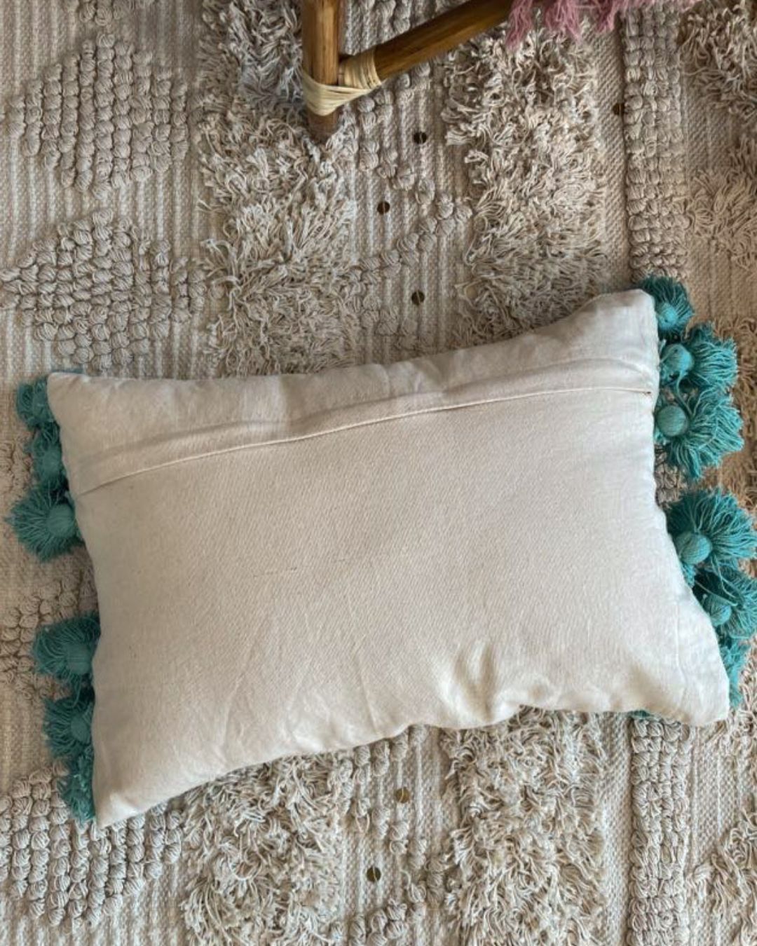 A bohemia-themed tassled and frilled pillow, showcasing its intricate design and earthy, vibrant colors. The decorative fringes and tassels add a touch of whimsical charm to the pillow, creating a unique and inviting decor piece.
