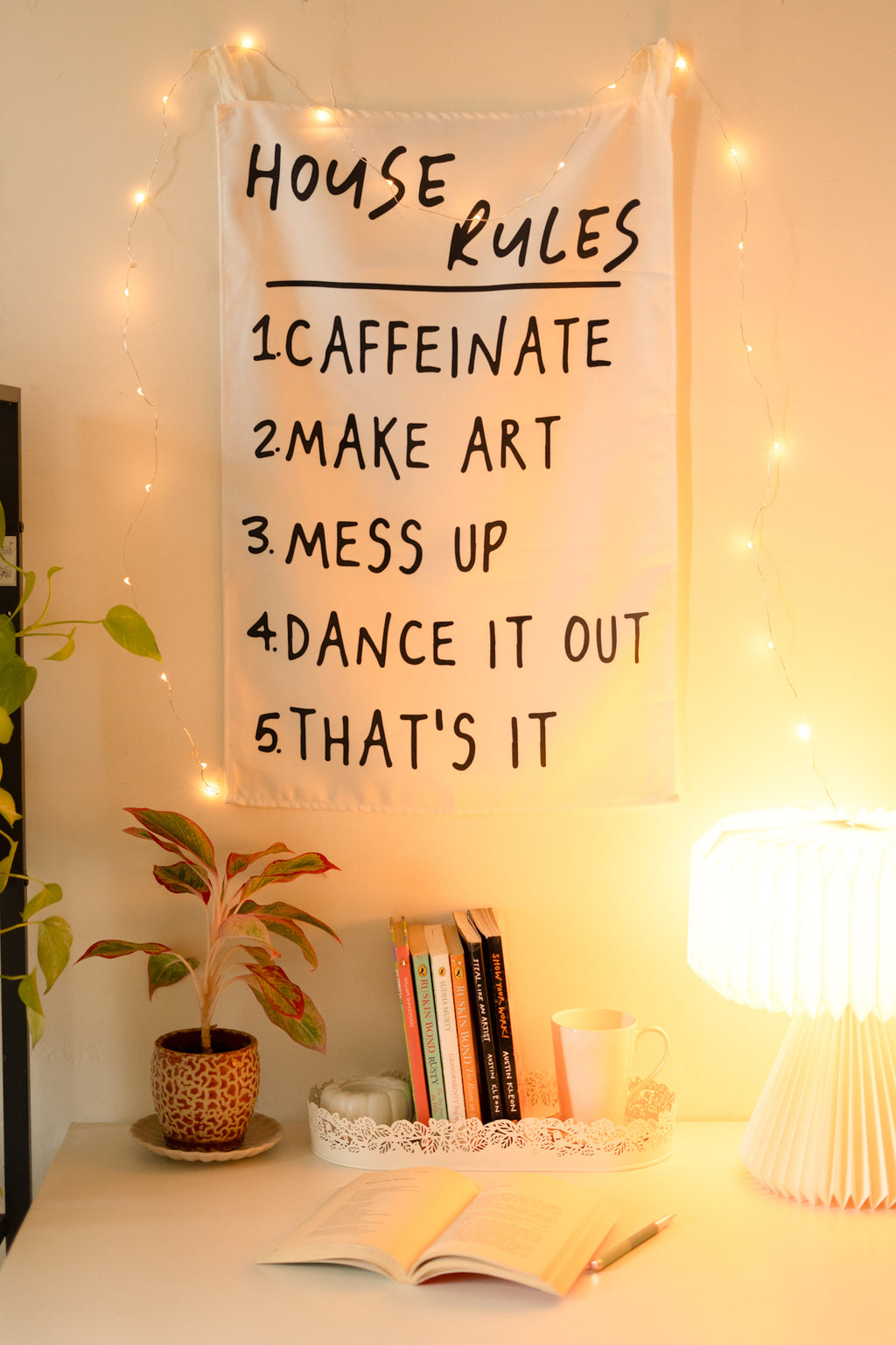 Frontal view of “The Boho Code” tapestry hanging on a neutral wall, featuring boho-inspired typography and colorful design.

