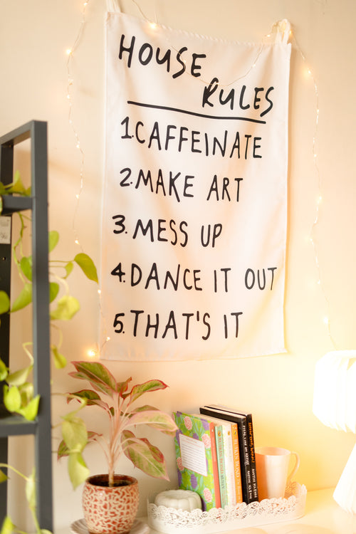 Side angle of “The Boho Code” tapestry displayed above a wooden console with potted plants and bohemian décor.

