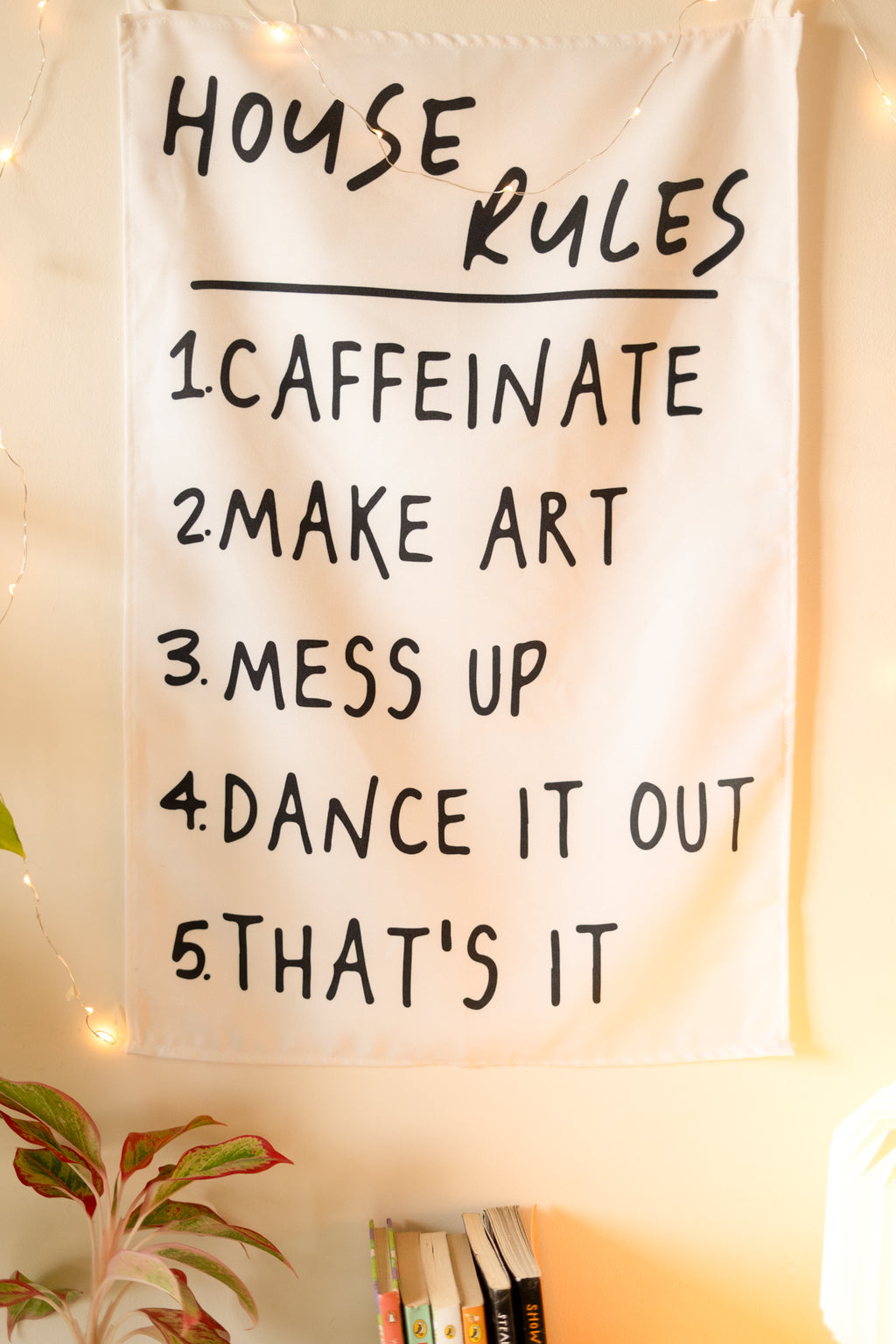 Frontal view of “The Boho Code” tapestry hanging on a neutral wall, featuring boho-inspired typography and colorful design.

