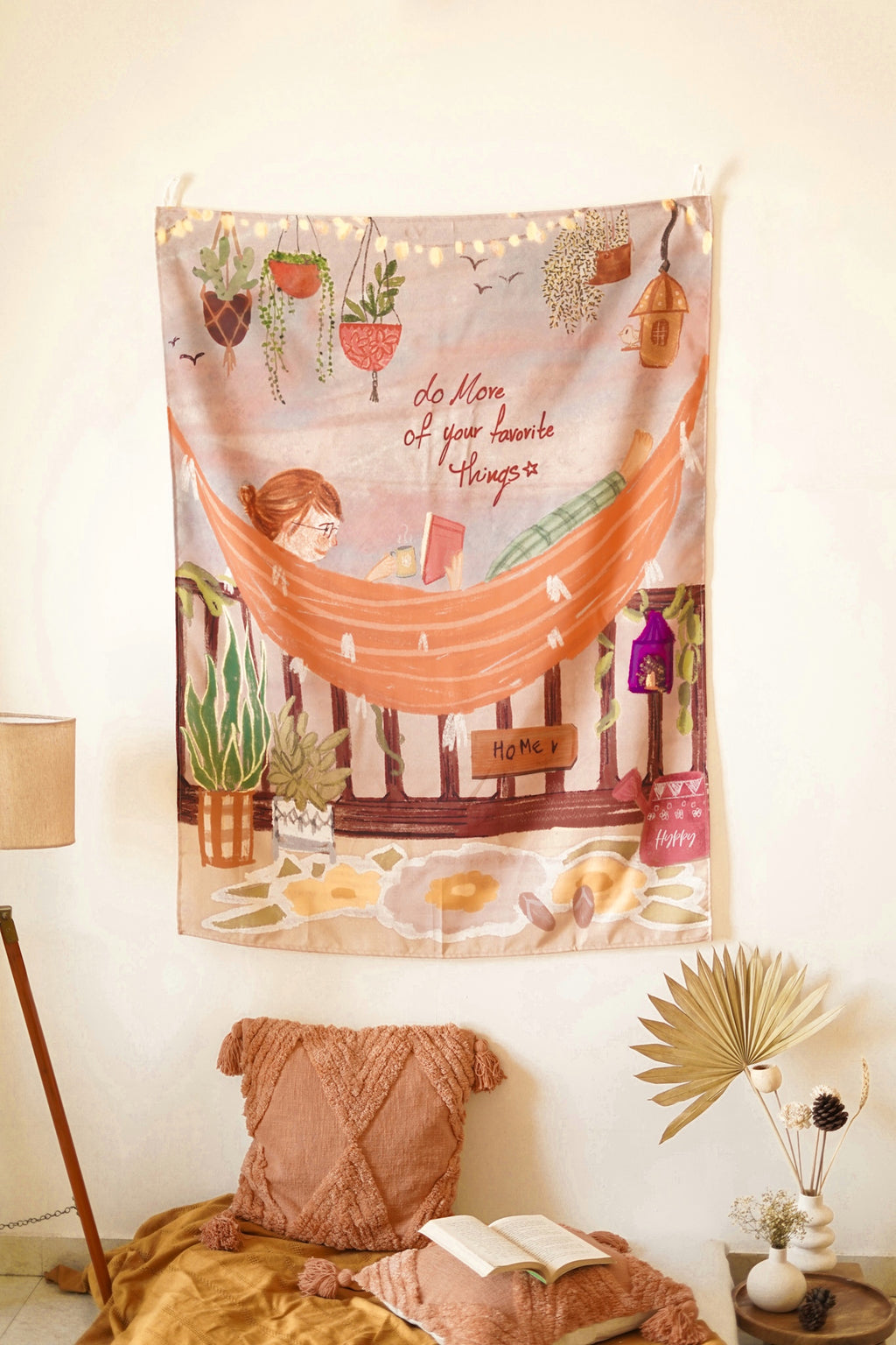 Aesthetic wall setup with illustrated cotton tapestry hung above a neutral-toned bench and soft furnishings.

